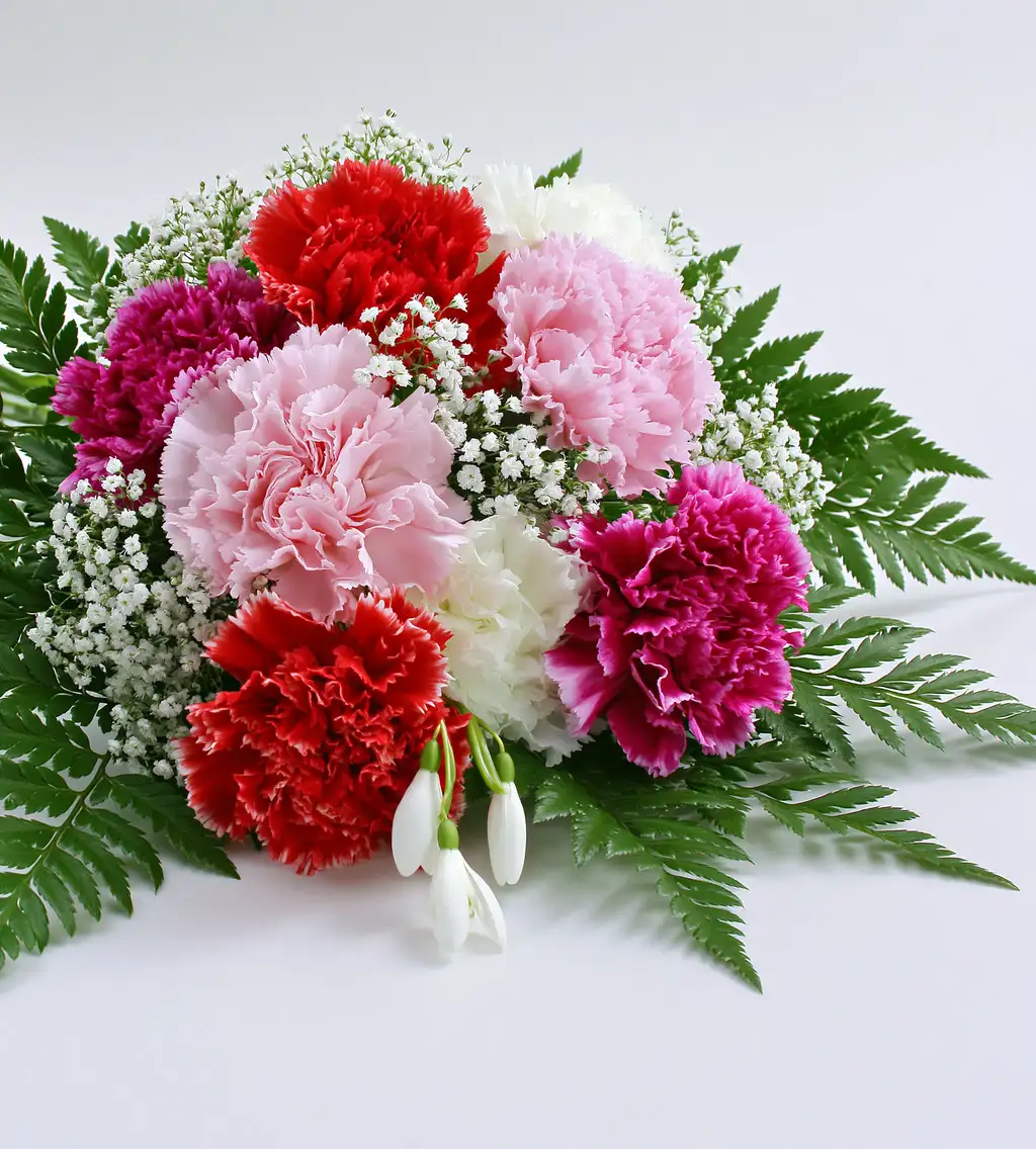 Colorful floral arrangement of multi colored carnations and green foliage